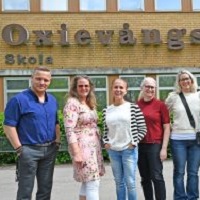 Foto av fem personer utanför en skolbyggnad. Fyra kvinnor och en man.